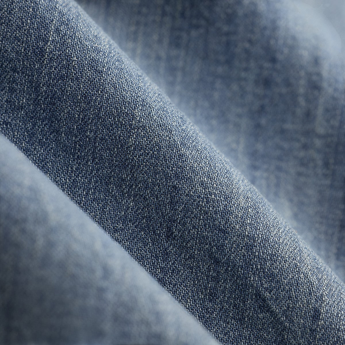 RRL indigo cotton denim fabric with a subtle herringbone pattern and a heavily washed lived-in texture.