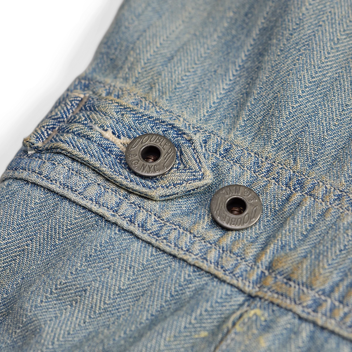 RRL distressed indigo herringbone cotton coverall detail featuring vintage metal buttons and reinforced stitching