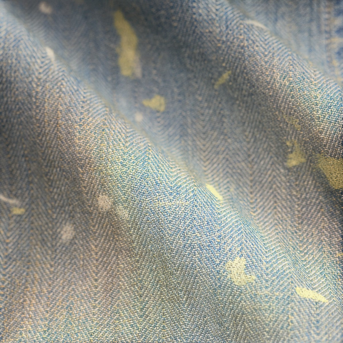 RRL distressed indigo cotton herringbone fabric with paint splatter details and a vintage lived-in texture.