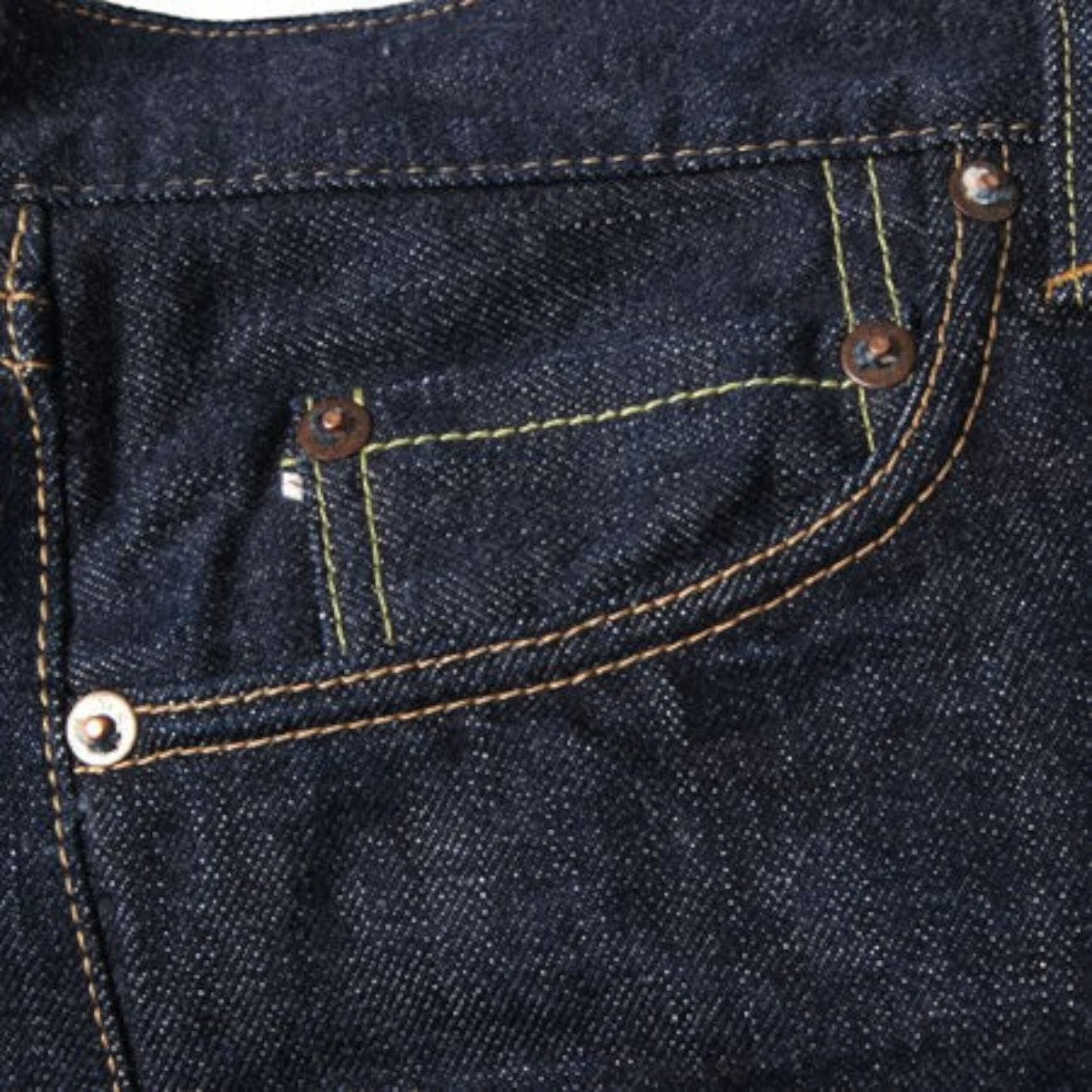 MILWORK dark indigo selvedge denim jeans with copper rivets and contrast stitching.
