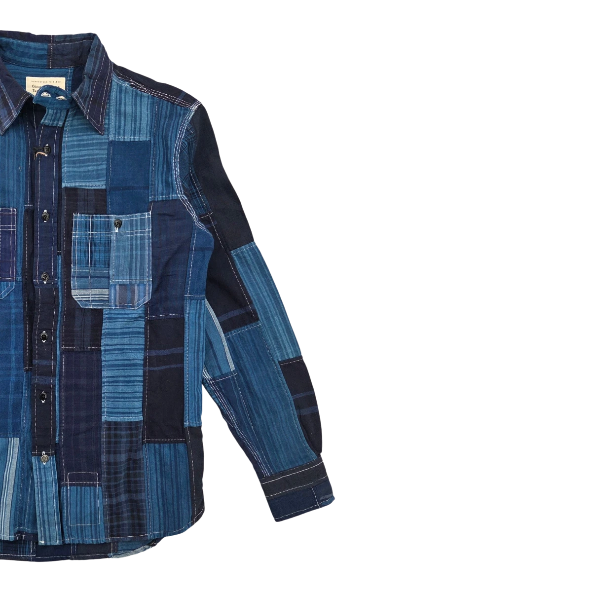 MILWORK indigo patchwork utility shirt made from pure cotton oxford cloth with a rugged finish. Features button-down front and chest pockets.