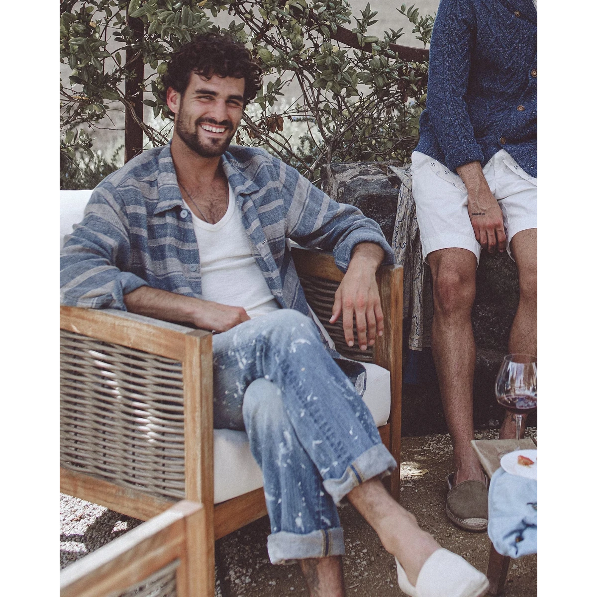 MILWORK Indigo cream striped linen dobby overshirt with metal buttons and patch pockets, worn by a man sitting in a chair.