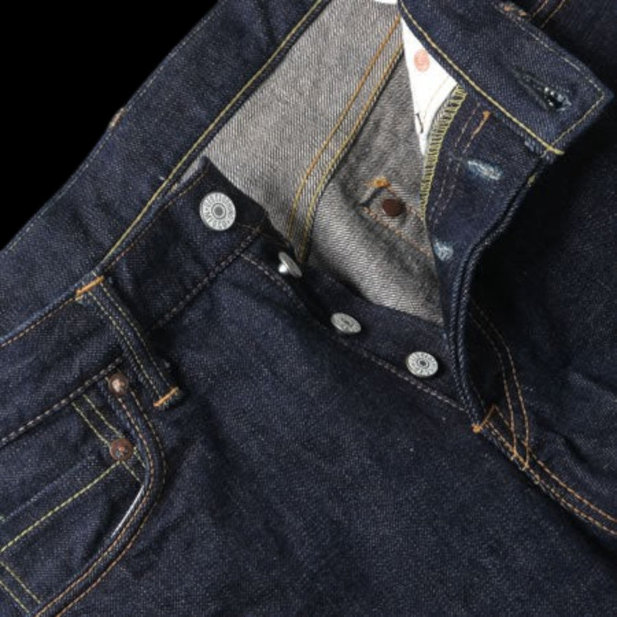 MILWORK Regular Straight Denim Once Wash Selvedge jeans in dark indigo raw denim with button fly and contrast stitching.