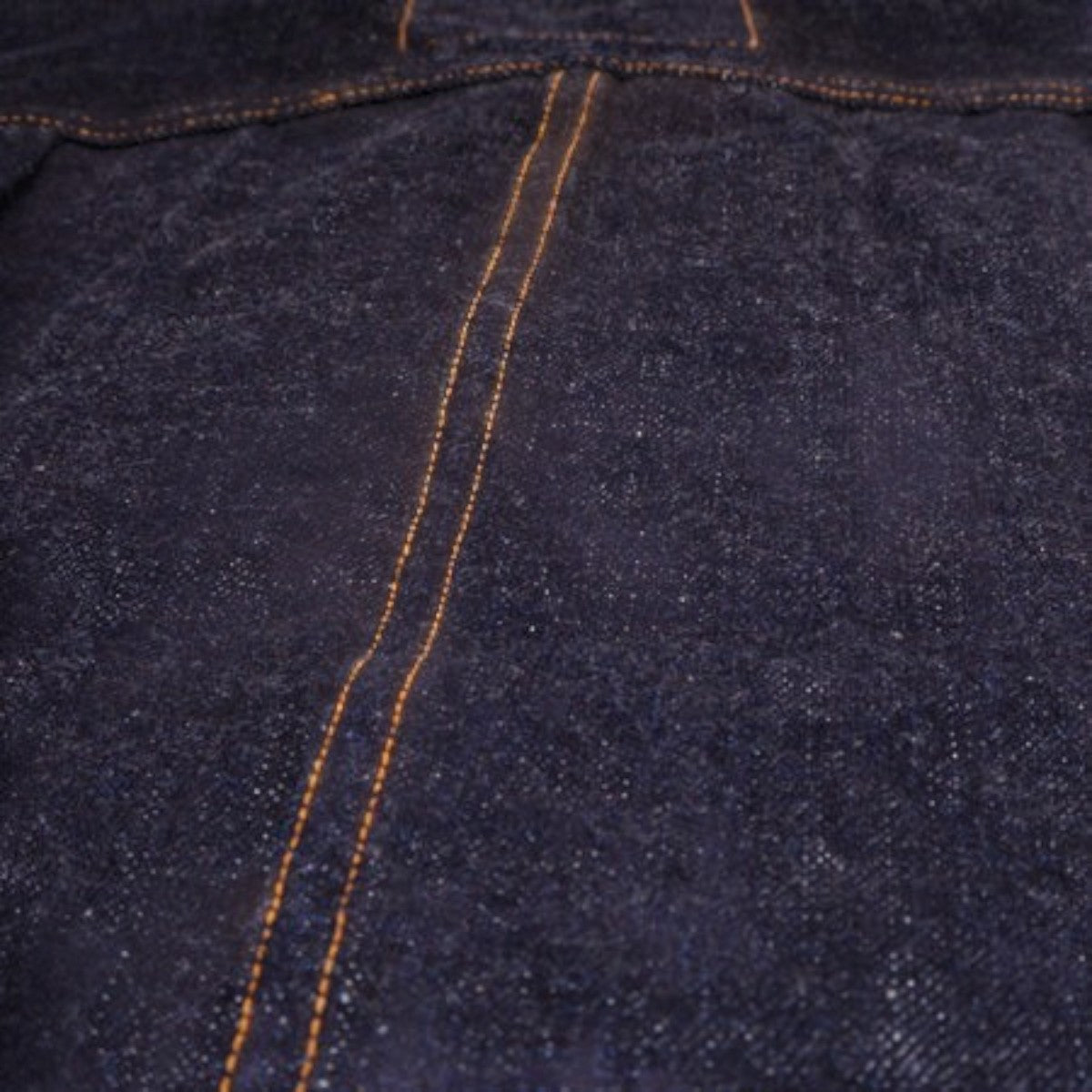 MILWORKS 17oz indigo denim fabric texture with thick orange contrast stitching on a vintage style jacket