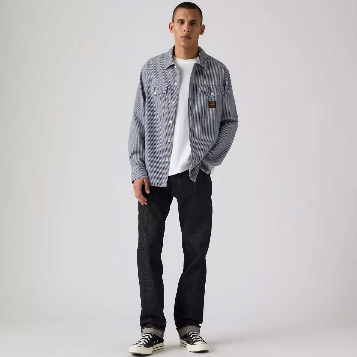 MILWORKS model wearing dark wash neppy rigid selvedge 505 regular fit jeans with a white t-shirt and striped shirt