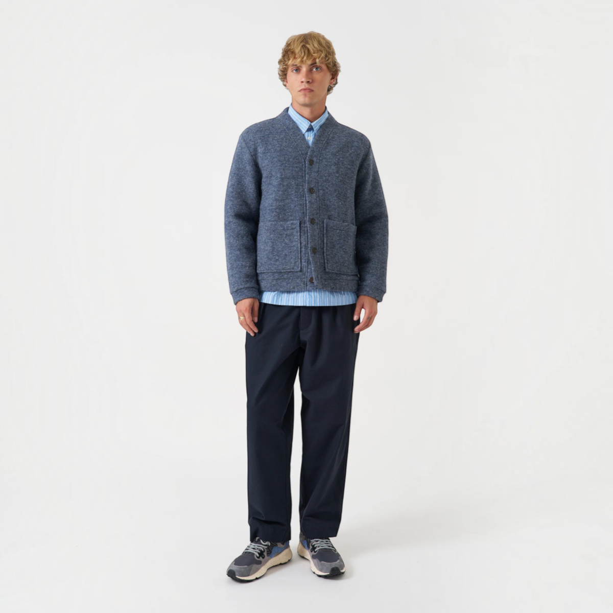 Model wearing a MILWORKS slate blue wool fleece cardigan with a boxy fit, front pockets, and elasticated hem.