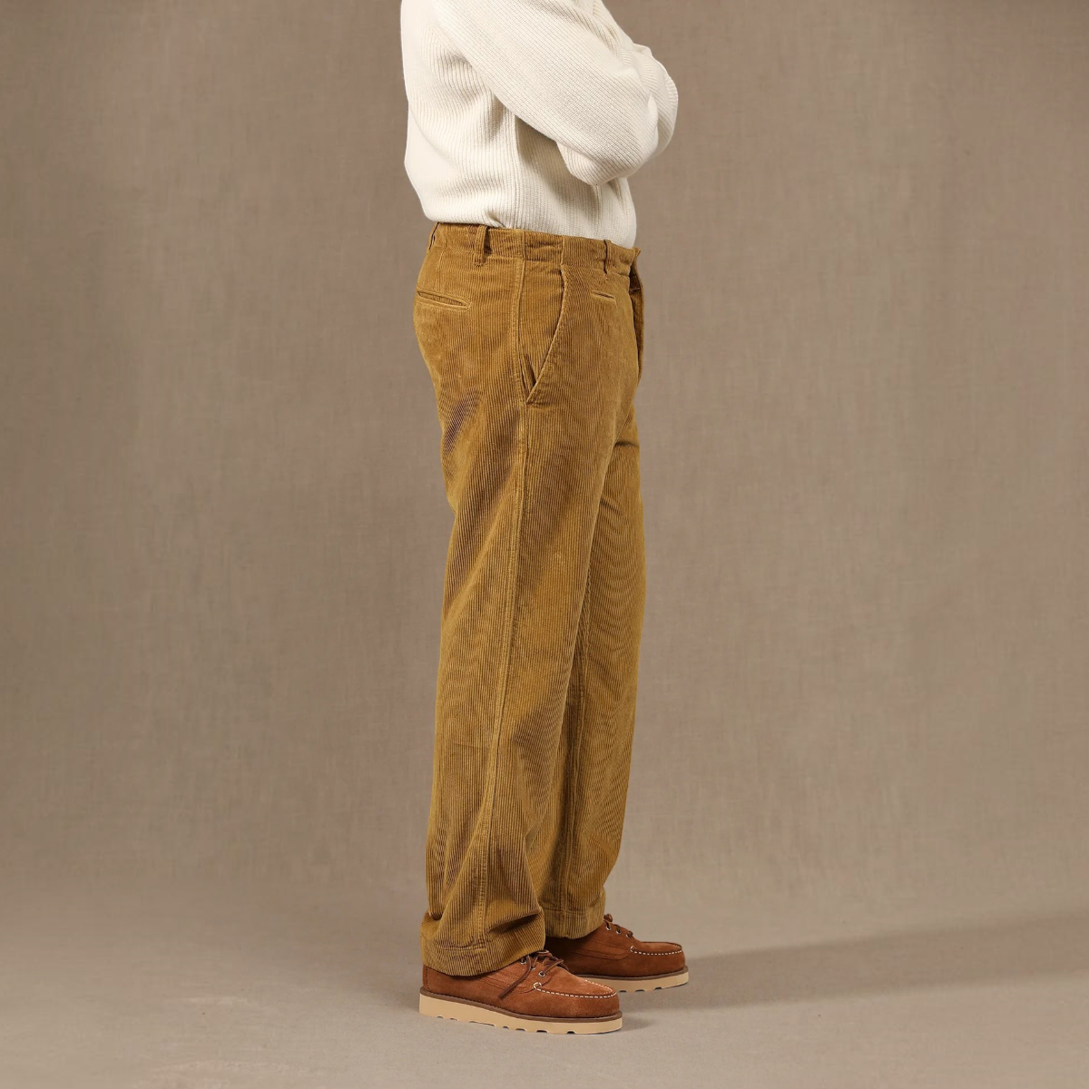 MILWORKS Axel mustard corduroy chino trousers in a relaxed fit, worn by a model in a side profile view.