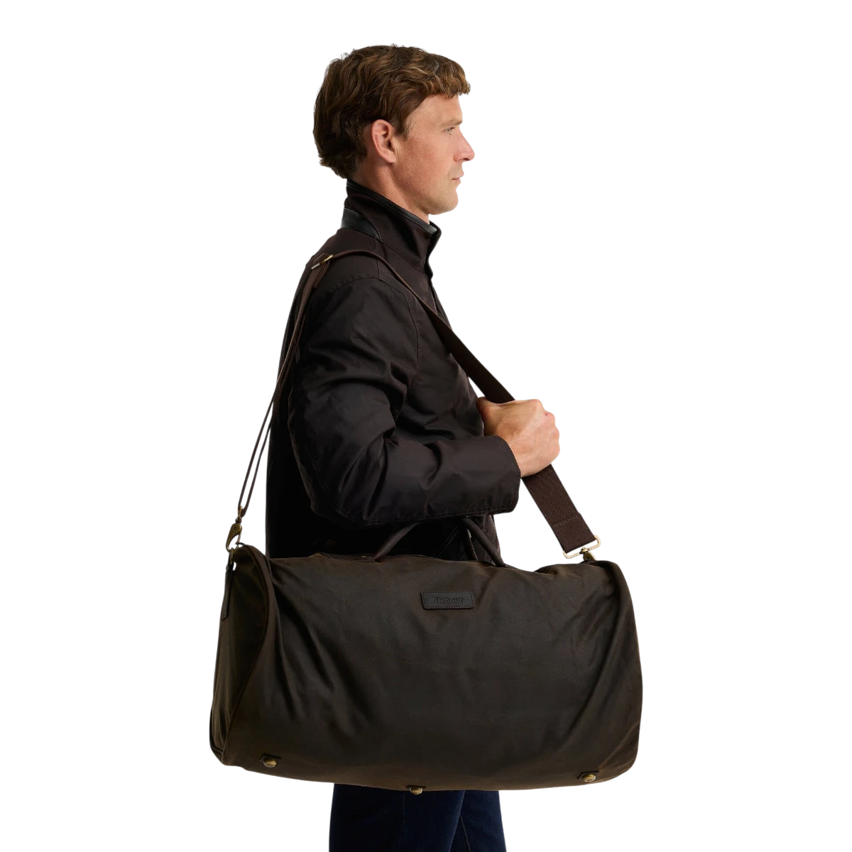 MILWORKS Barbour olive waxed cotton holdall bag with leather trim and shoulder strap carried by a man in profile