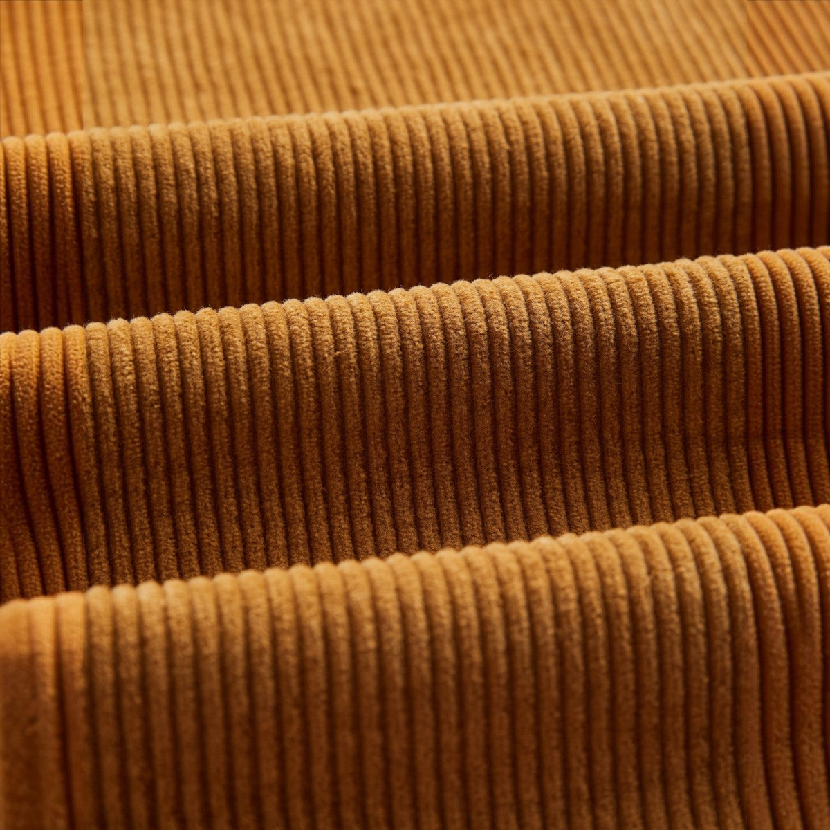 Close-up of milworks.momrduroy trousers fabric in a warm autumn brown shade with soft vertical ridges