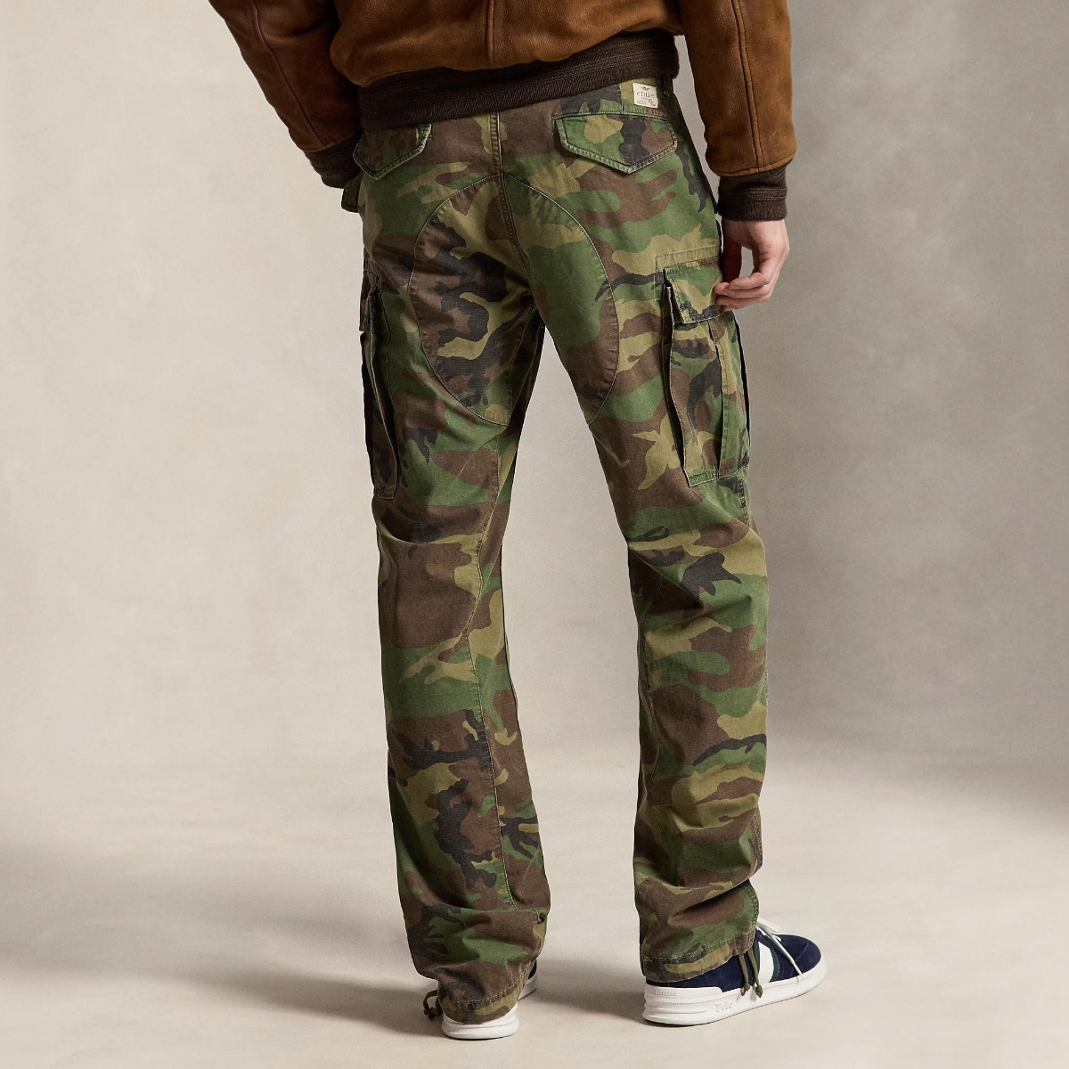 Rear view of MILWORKS camo canvas cargo pants with snapped pockets, drawstring hems, and a vintage-washed finish.