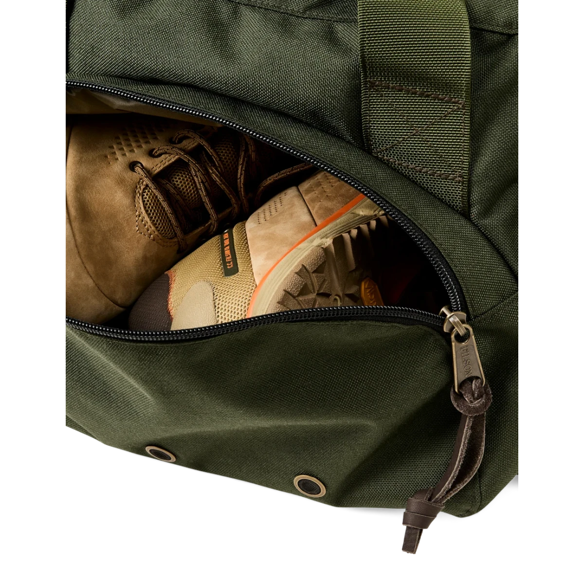 MILWORKS Dryden Duffle Pack in otter green nylon showing the expandable side compartment containing hiking boots