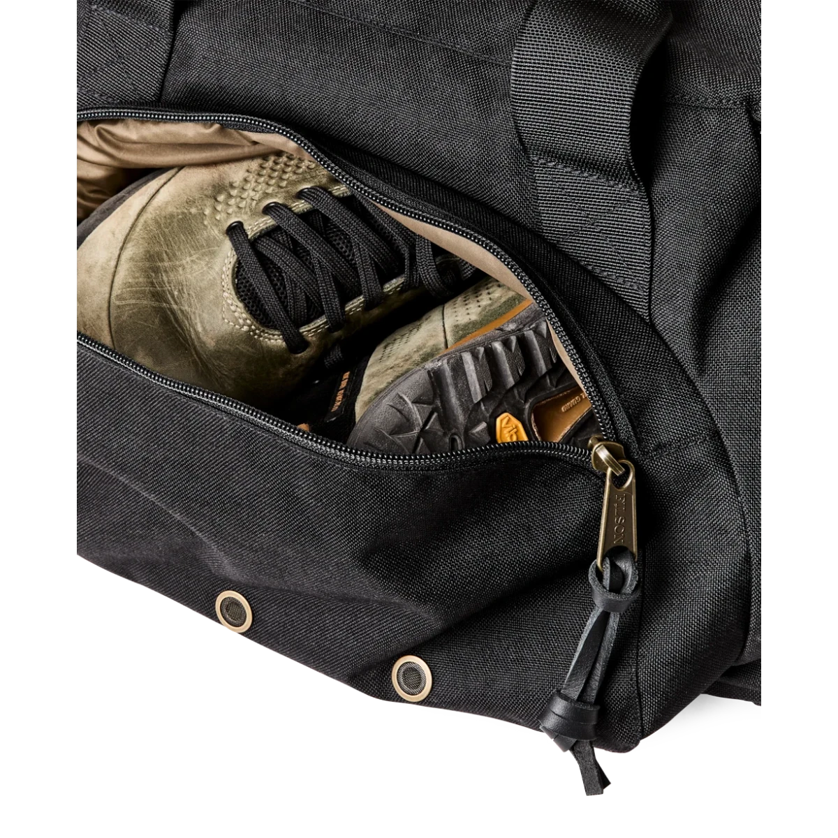 MILWORKS Dryden Duffle Pack in black nylon showing the expandable side pocket compartment containing a pair of shoes.