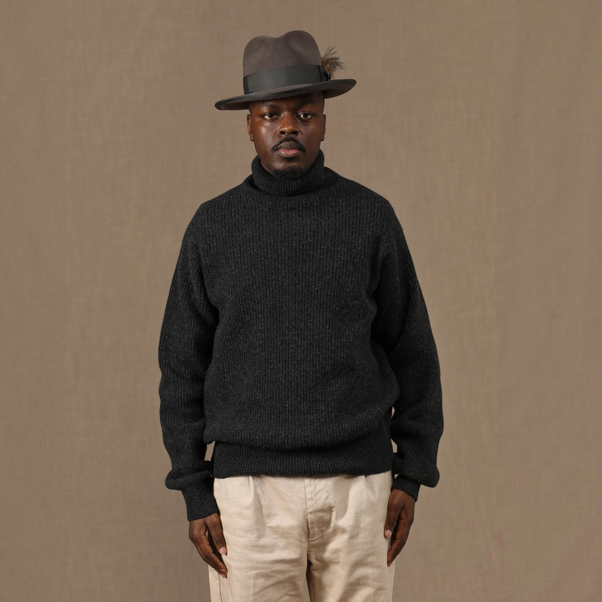 MILWORKS East Harbour Surplus grey wool blend turtleneck sweater worn by a man in a fedora hat
