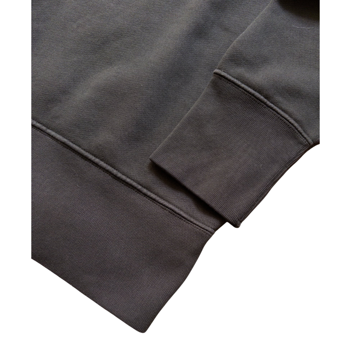 MILWORKS faded black cotton crewneck sweatshirt showing detailed view of the long ribknit cuff and hem