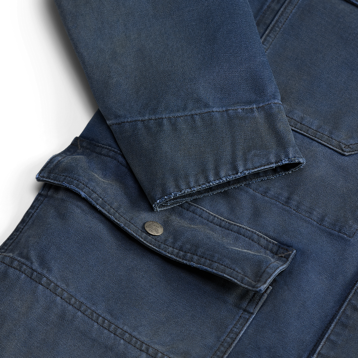 MILWORKS faded navy cotton canvas engineer jacket featuring a snap-button pocket and rugged vintage-inspired texture.