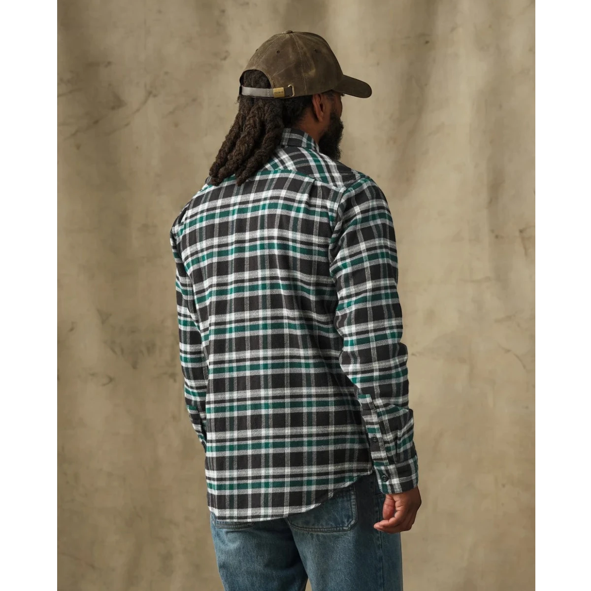 MILWORKS Filson vintage flannel work shirt in black and green plaid, back view on a man wearing a brown cap