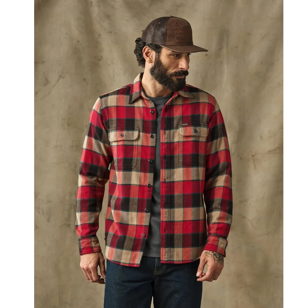 MILWORKS Filson vintage red and cream plaid flannel work shirt with button-flap chest pockets on a bearded model.
