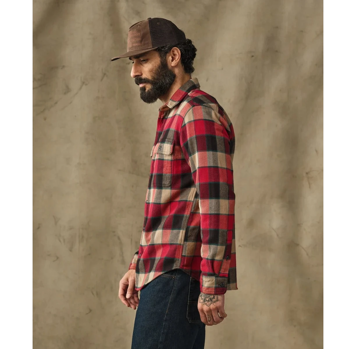 MILWORKS Filson vintage red and cream plaid flannel work shirt worn by a bearded man in a brown trucker hat