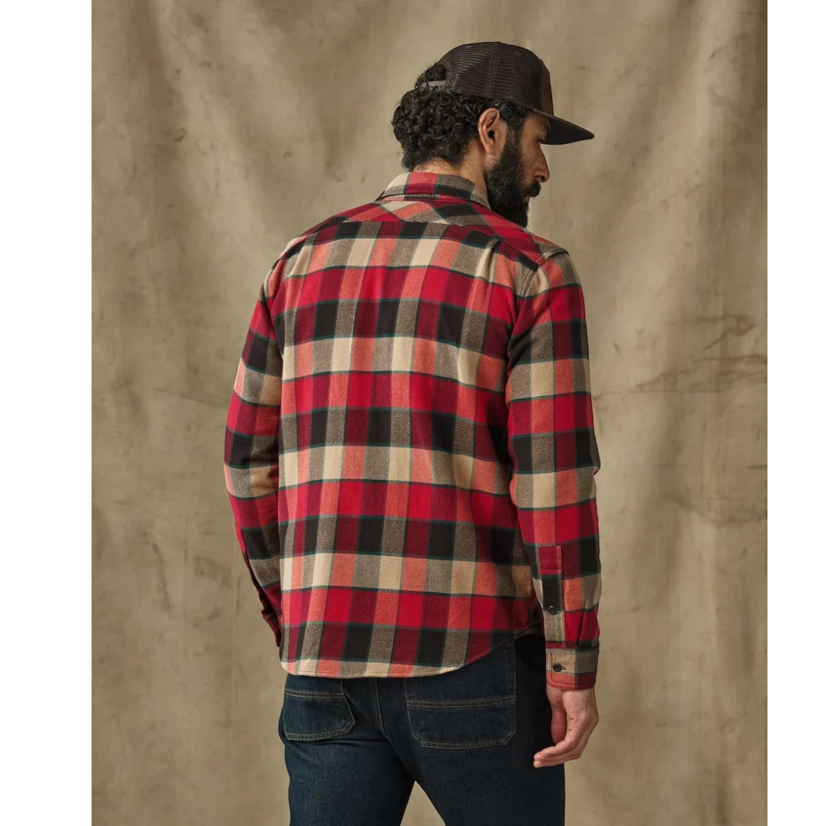 MILWORKS Filson red and cream plaid flannel work shirt on a man seen from the back, showing shoulder pleats.