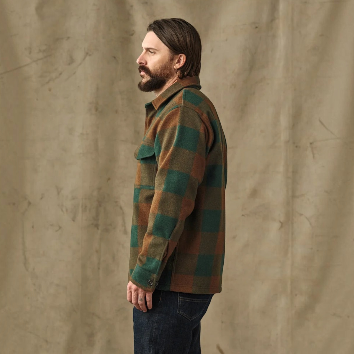 MILWORKS Filson wool jac-shirt in bronze green plaid worn by a man in a side profile view