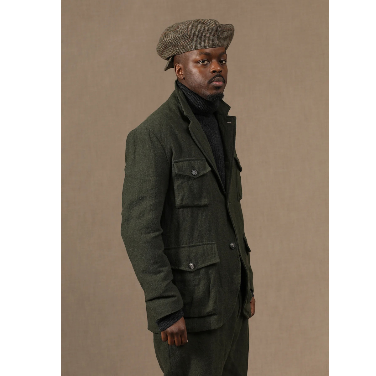 MILWORKS model wearing a green wool-linen blend sport jacket with four patch pockets and horn buttons.