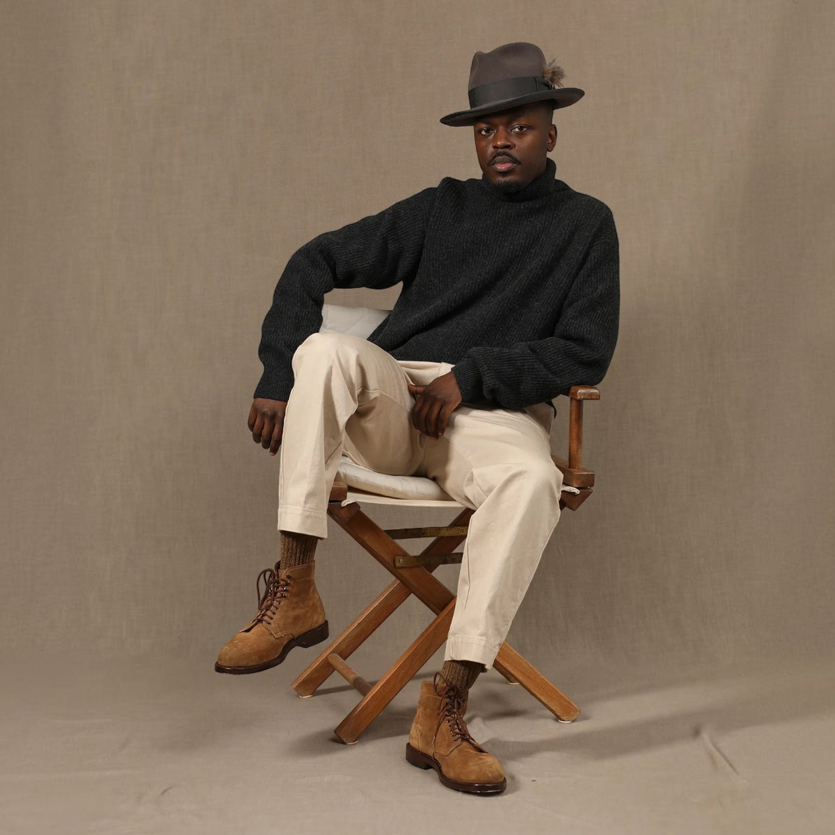 MILWORKS model wearing a grey East Harbour Surplus wool blend turtleneck sweater with beige trousers and suede boots