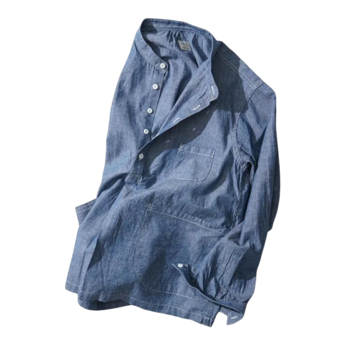 MILWORKS indigo chambray pullover work shirt with a boxy fit, button-up collar, and oversized front pockets.