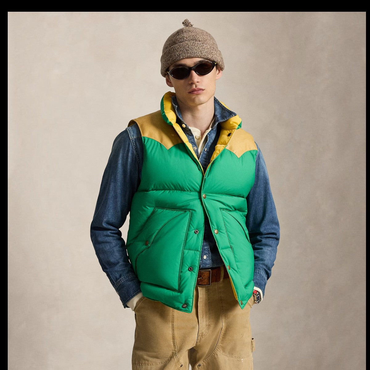 MILWORKS model wearing a green and yellow down vest with a leather Western-style yoke over a denim shirt
