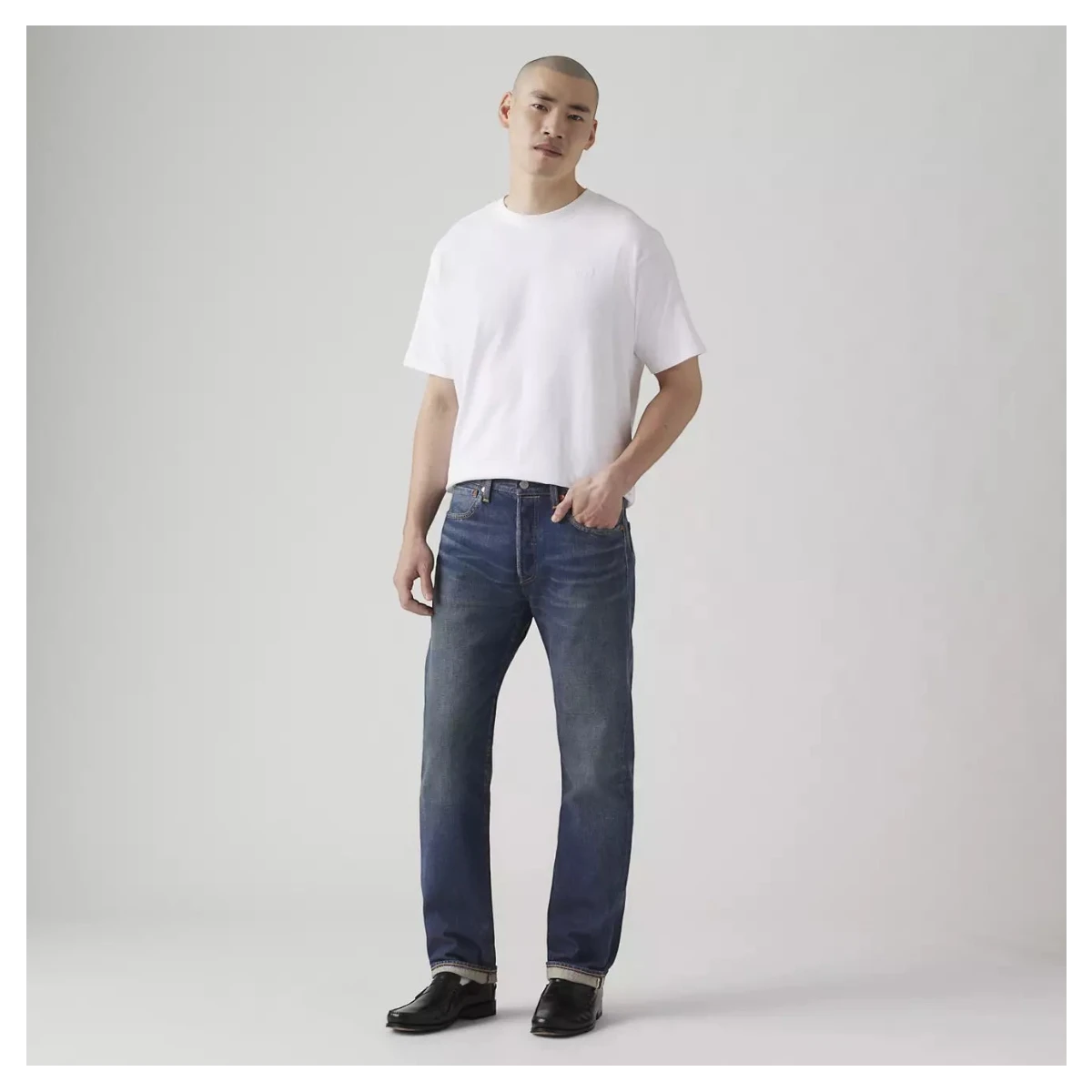 MILWORKS model wearing Levi's 501 Original selvedge jeans in dark wash with a straight leg fit and cuffed hem