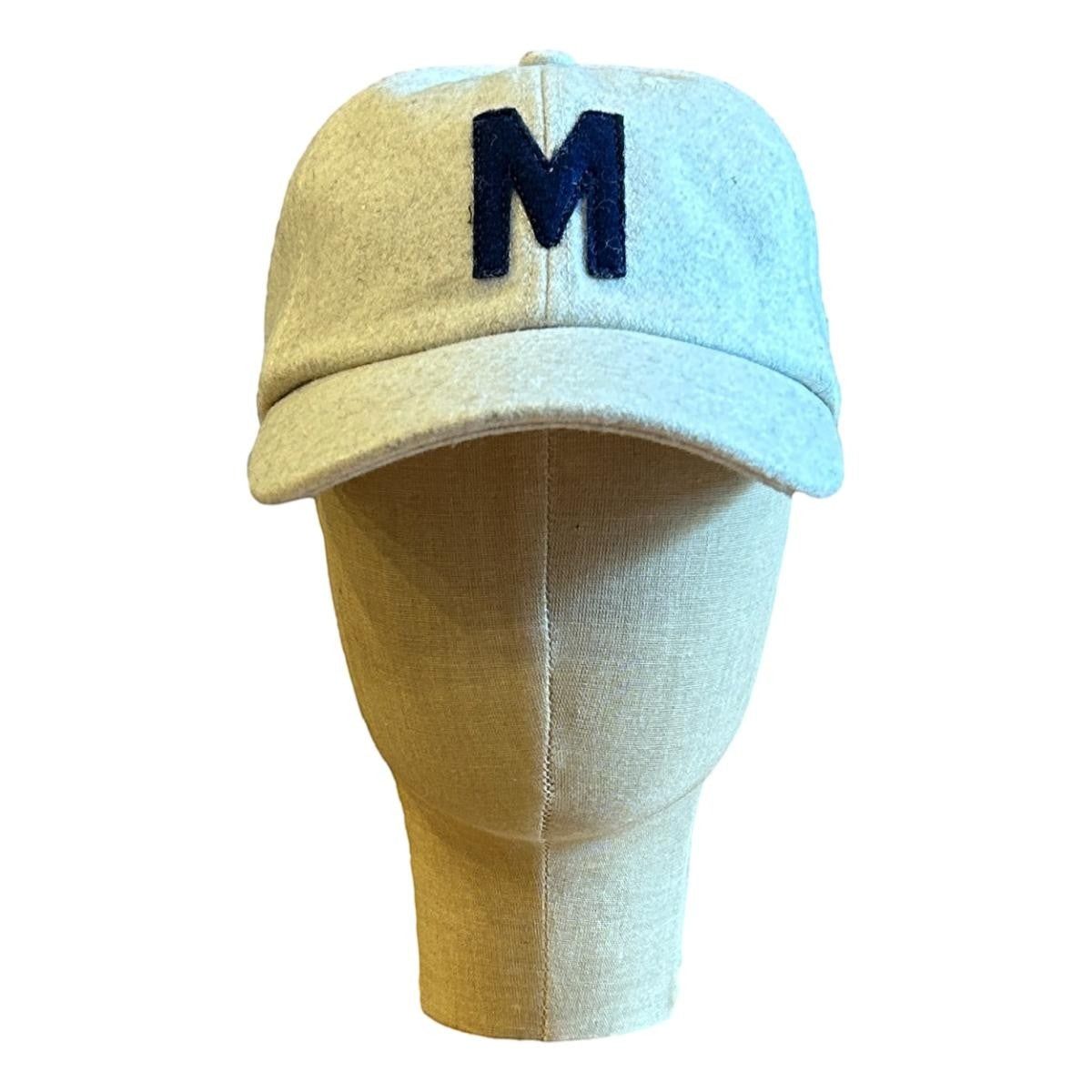 MILWORKS oat wool blend cap with navy felt "M" applique, flat peak, and adjustable strap.