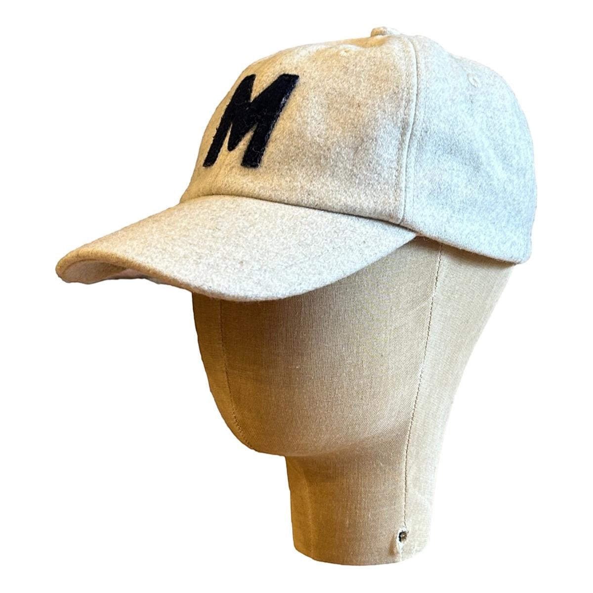 MILWORKS oat wool blend unstructured cap with flat peak and black felt "M" logo. Adjustable fastener with metal clasp.