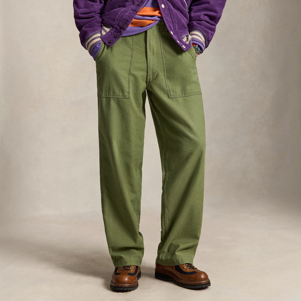 MILWORKS olive green relaxed fit utility pants in reverse-sateen cotton with front angled pockets on a model.