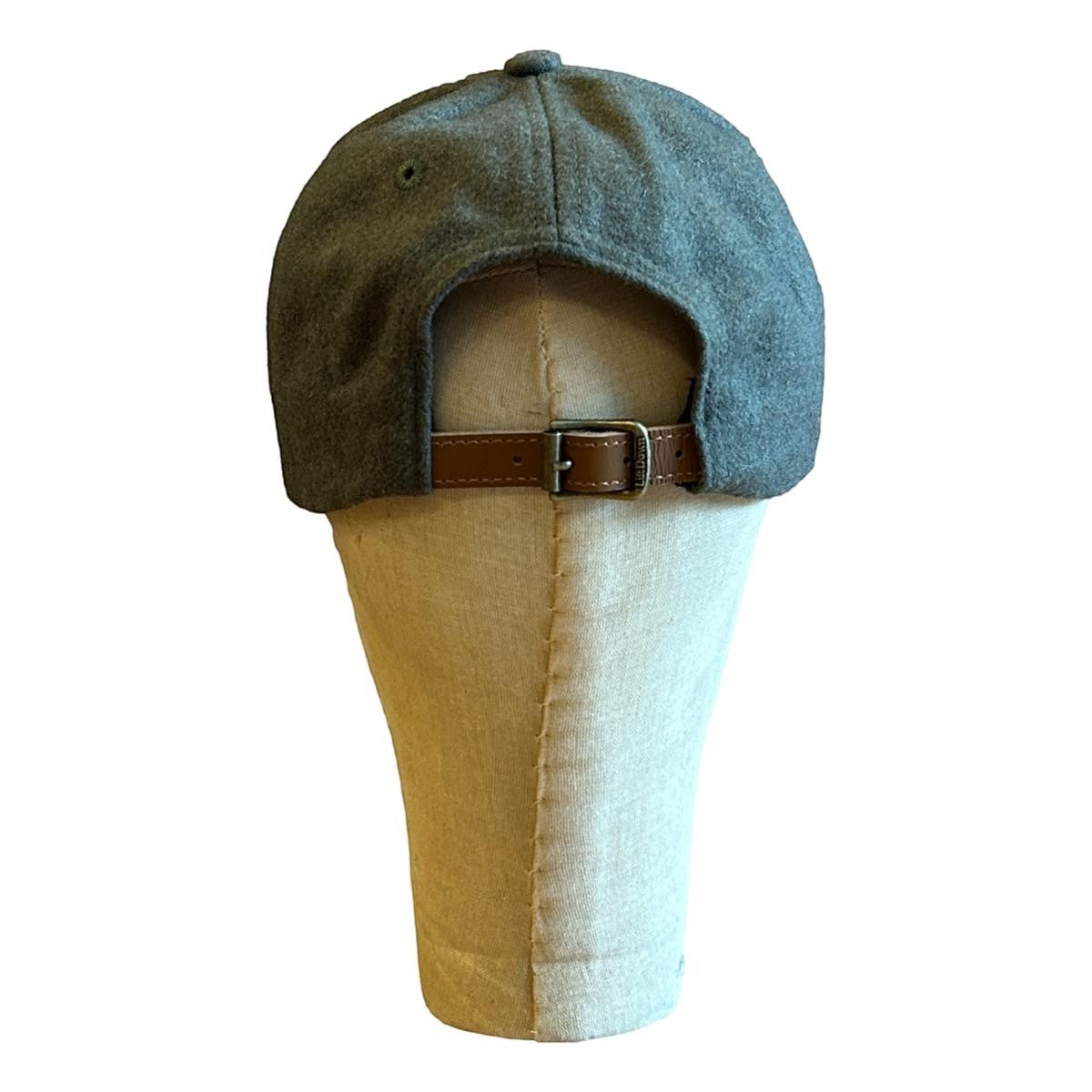 MILWORKS olive wool fieldhouse cap with adjustable leather strap and metal clasp. Unstructured design with flat peak.