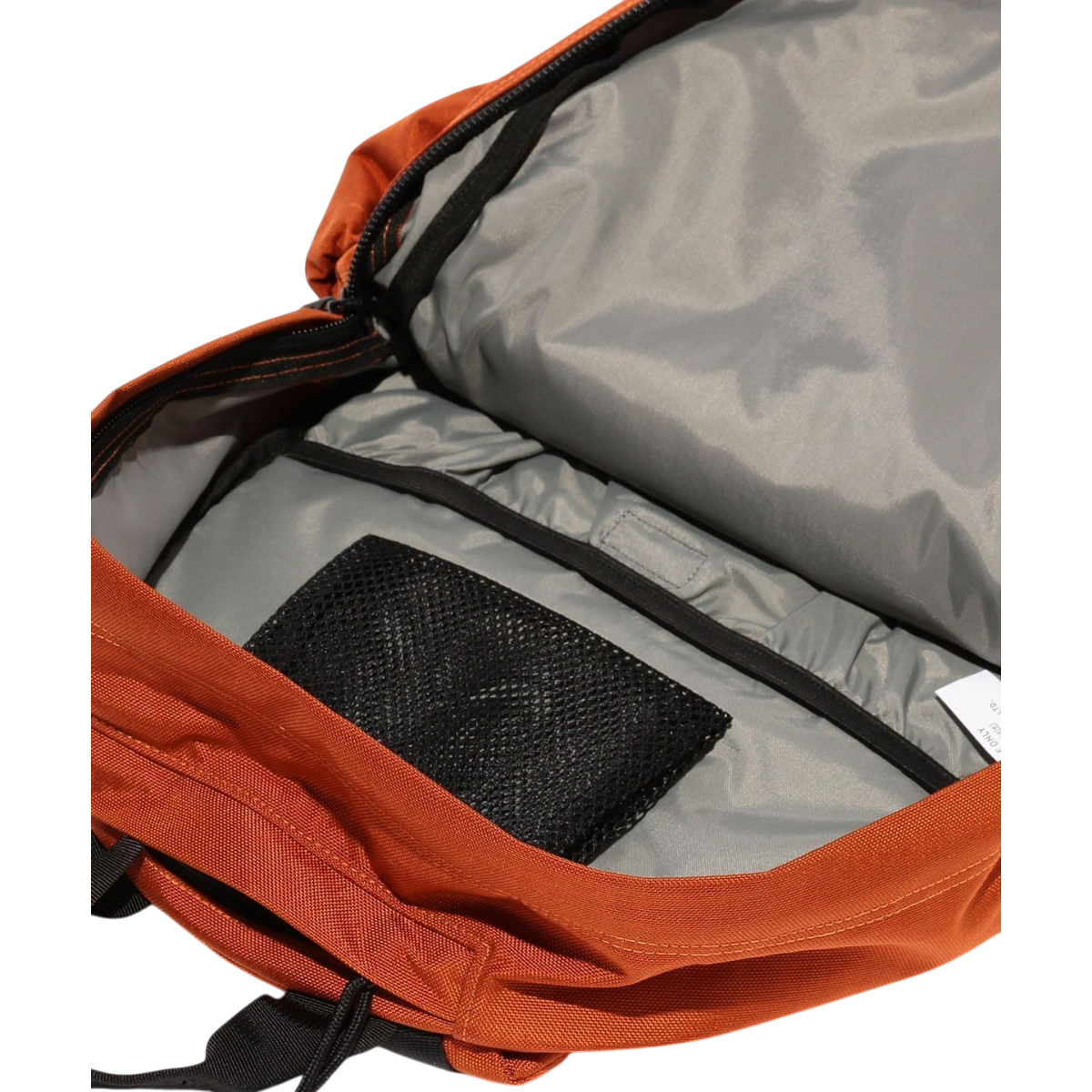 MILWORKS orange day pack interior showing a large main compartment with a black mesh pocket and grey lining