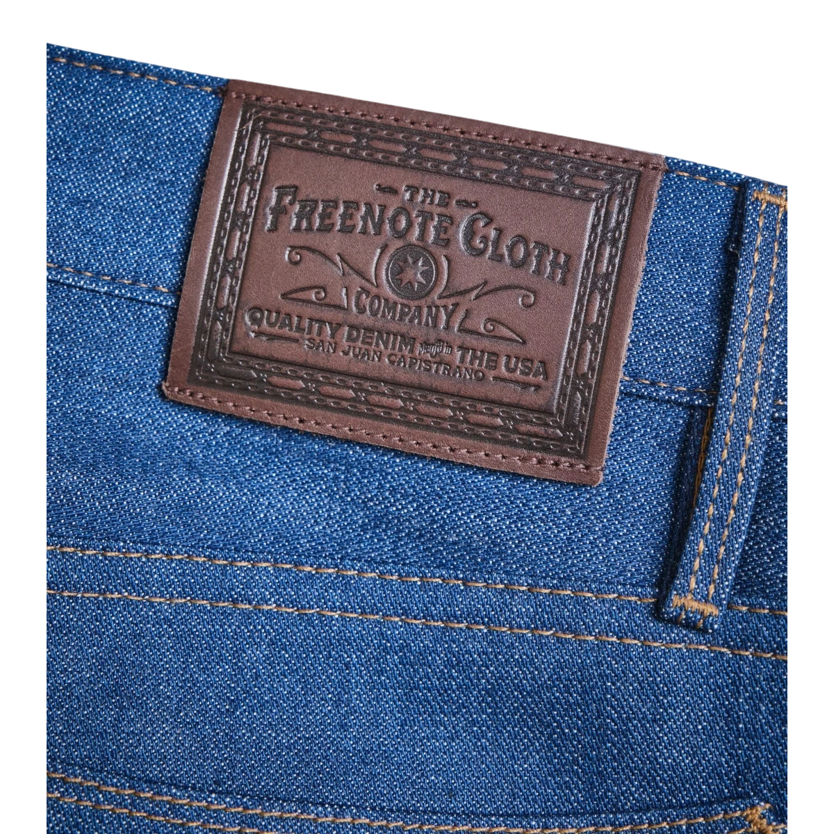 MILWORKS Portola Classic Taper jeans in vintage blue selvedge denim with leather patch and contrast stitching.
