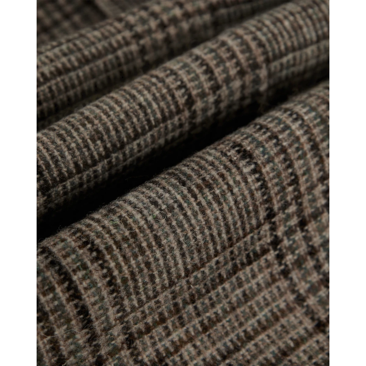 Close-up of MILWORKS Prince of Wales check virgin wool fabric in brown and green tones for single pleat trousers