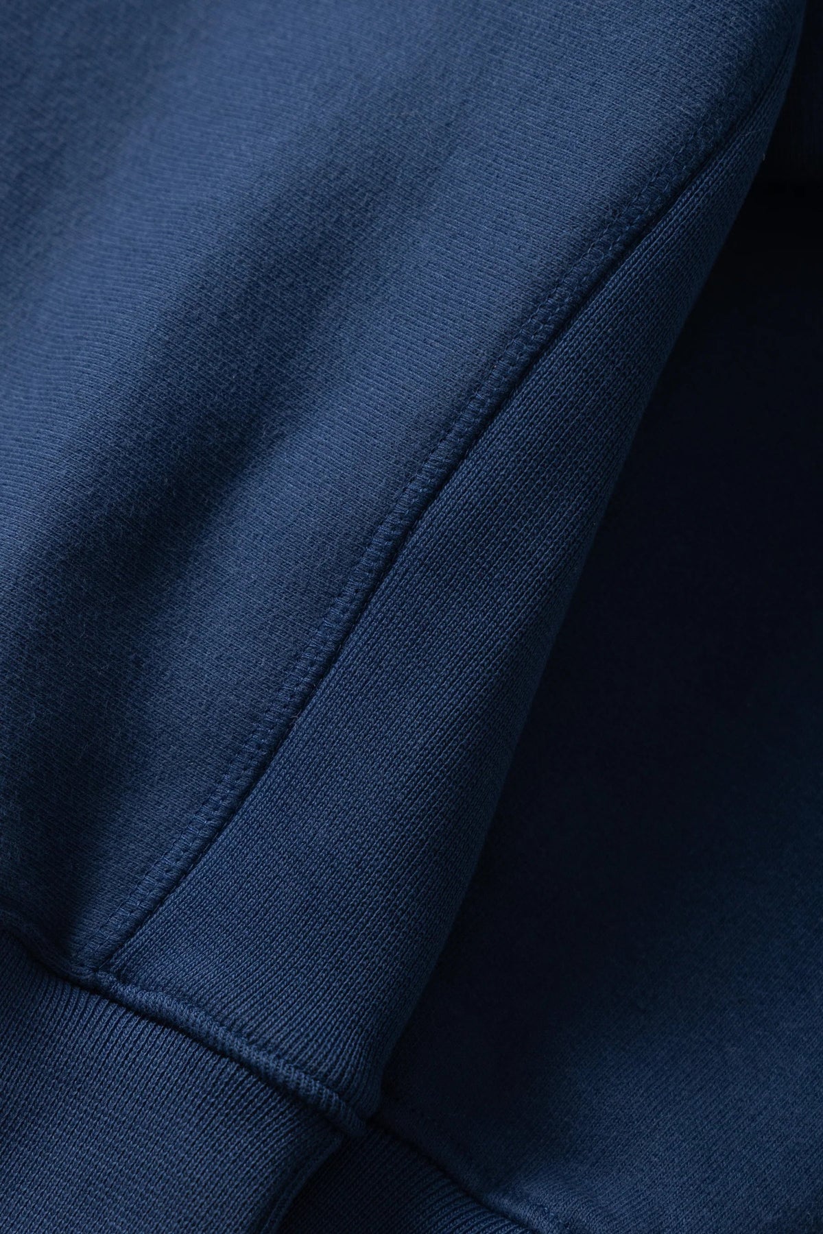Close-up of MILWORKS royal blue 16oz heavyweight organic cotton brushed fleece rugby shirt showing side ribbing detail