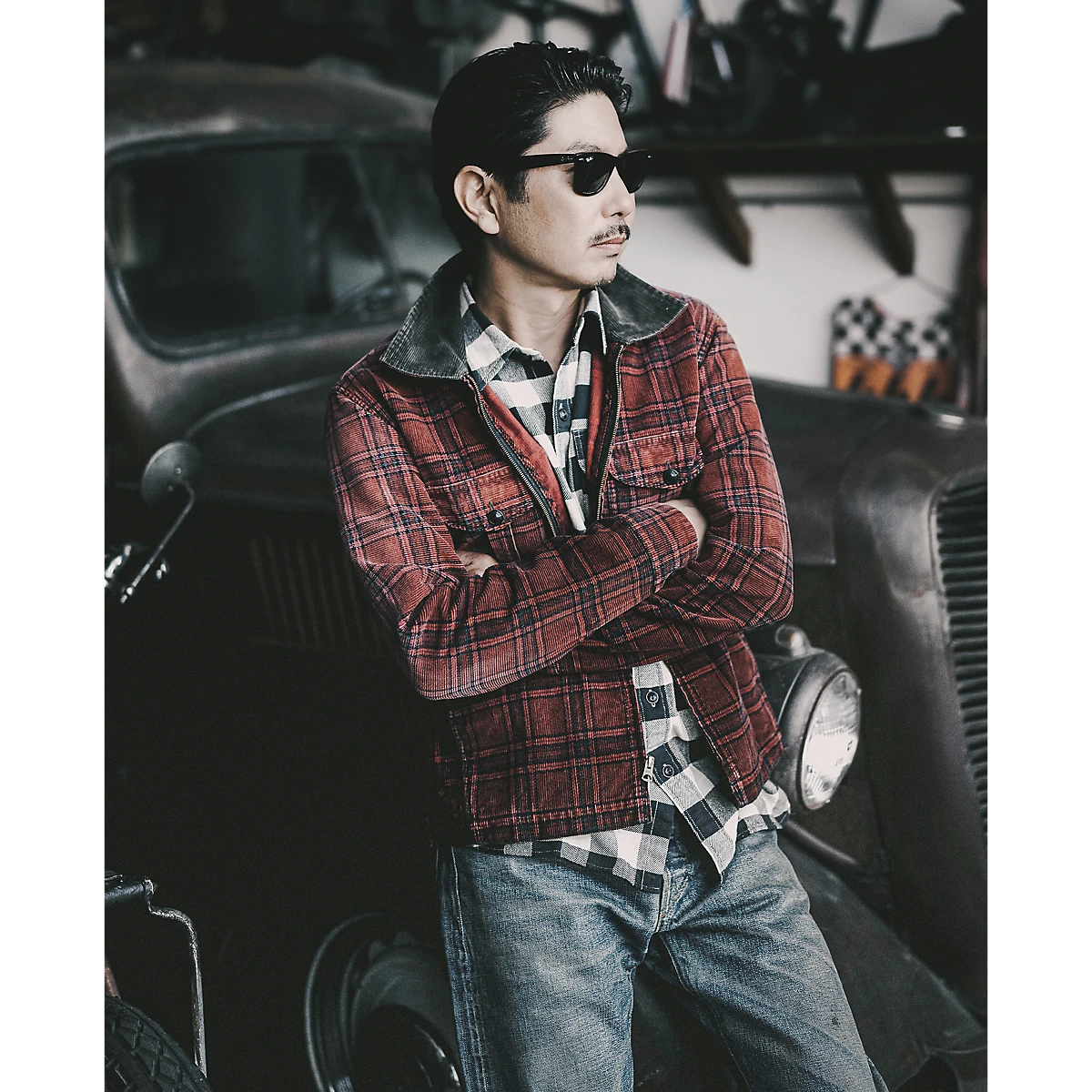 MILWORKS RRL red and black plaid corduroy overshirt worn by a man leaning against a vintage car