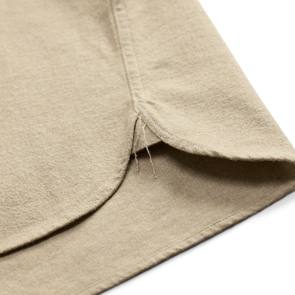 Close-up of the curved hem and side gusset detail on a MILWORKS RRL woven sport shirt in grey and cream linen fabric.
