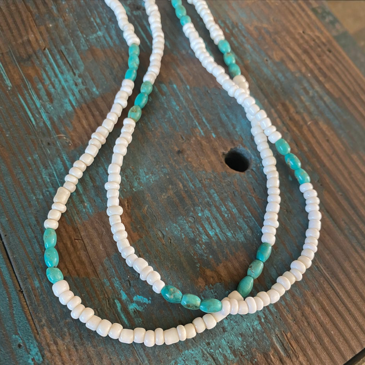 MILWORKS 26-inch necklace featuring genuine turquoise beads and white glass seed beads on a rustic wooden surface