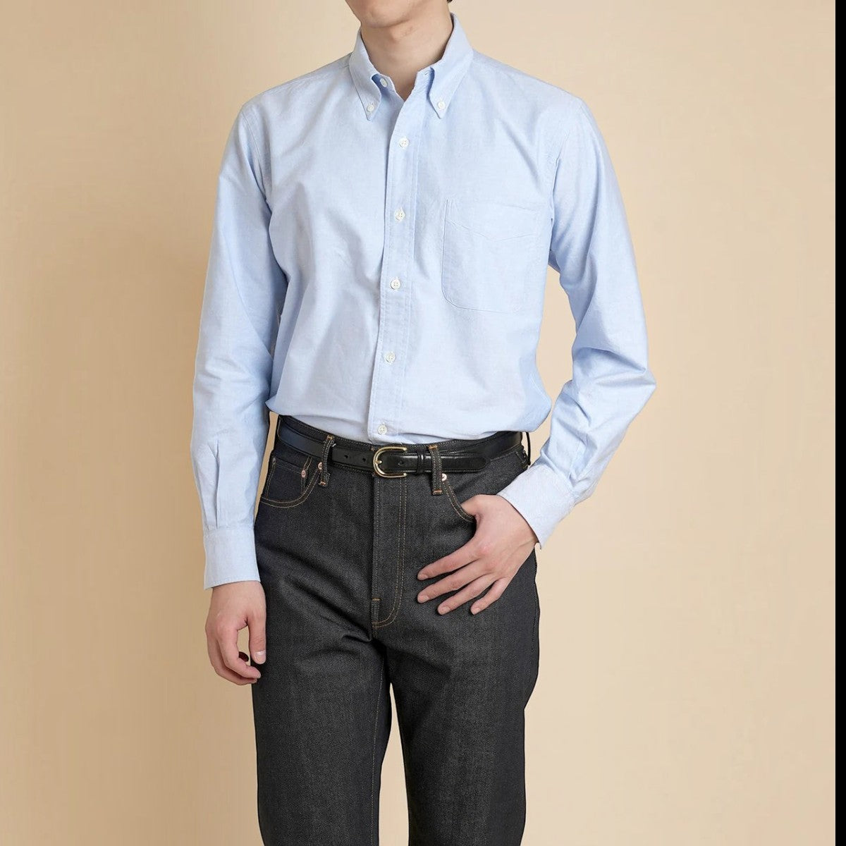 MILWORKS Vintage Ivy blue cotton oxford button-down shirt with chest pocket, worn by a model in dark denim jeans.