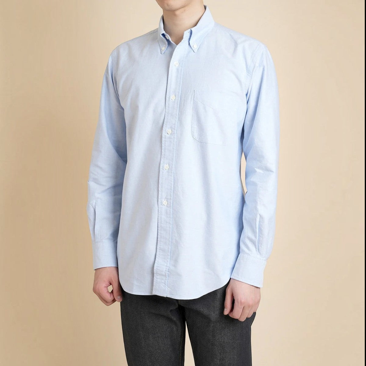MILWORKS light blue cotton oxford button-down shirt with chest pocket and long sleeves on a model.