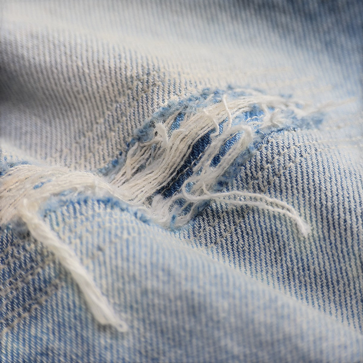 Close-up of Double RL vintage indigo denim jeans showing distressed fabric texture and frayed repair details